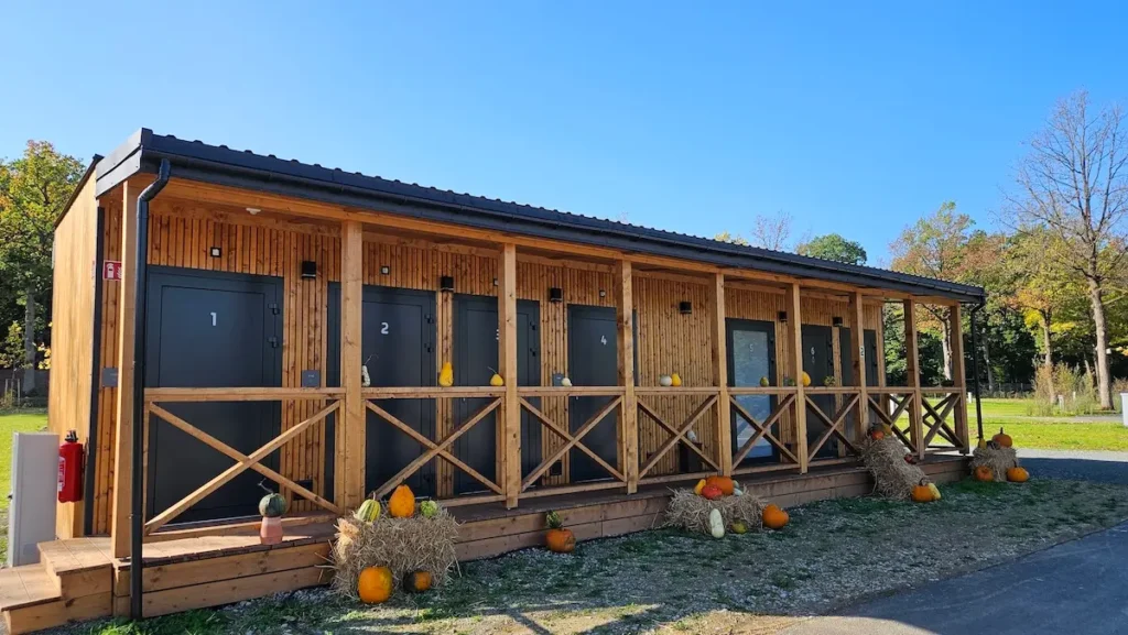 Sanitärgebäude aus Holz mit dunkel grauen Eingangstüren auf einem Campingplatz