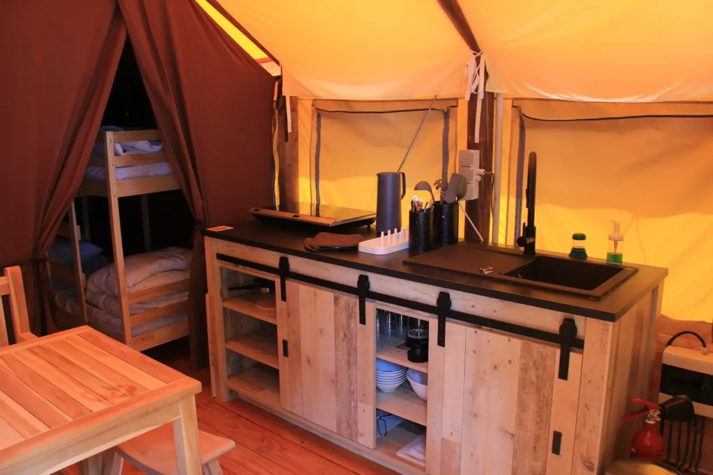 Blick auf die Küche in einem Lodge Zelt und dem Eingang zum Schlafzimmer