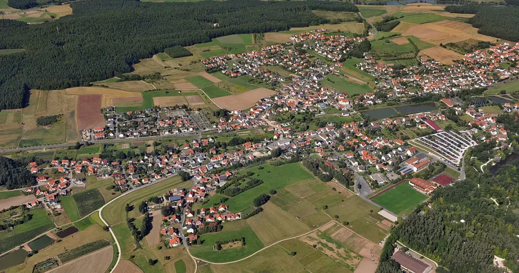 Luftaufnahme des Ortes Heroldsbach - ein bebauter Ort mit Wiesen und Wäldern