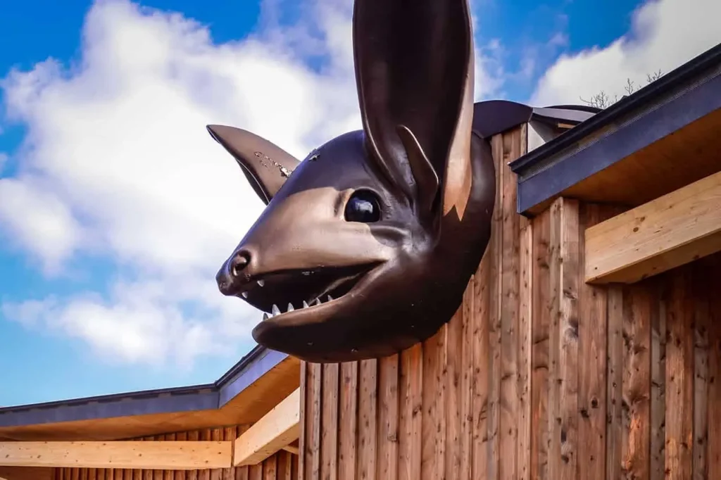 Der Kopf einer Fledermausfigur am oberen Teil einer Holzwand