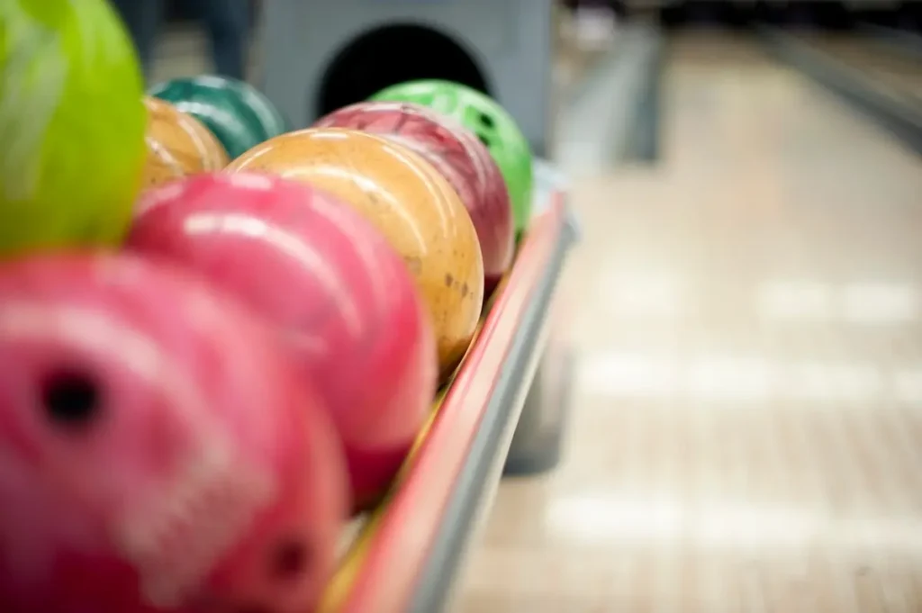 Bowlingkugeln in verschiedenen Farben befinden sich in der Sammelstation einer Bowlingbahn