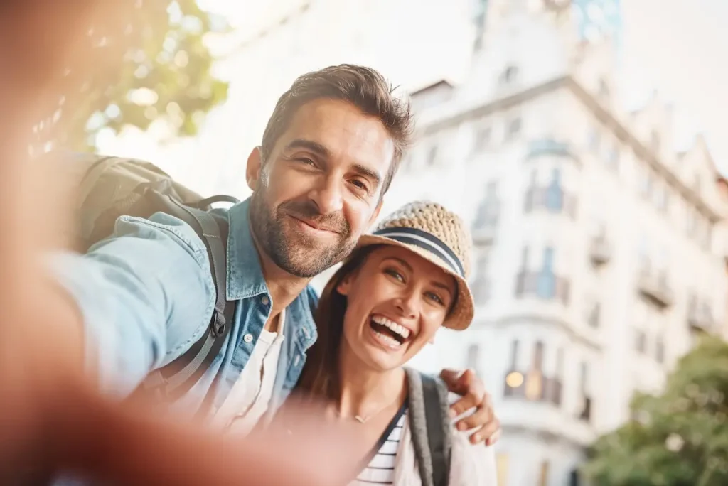Ein glückliches Paar macht ein Selfie vor einem Stadthaus