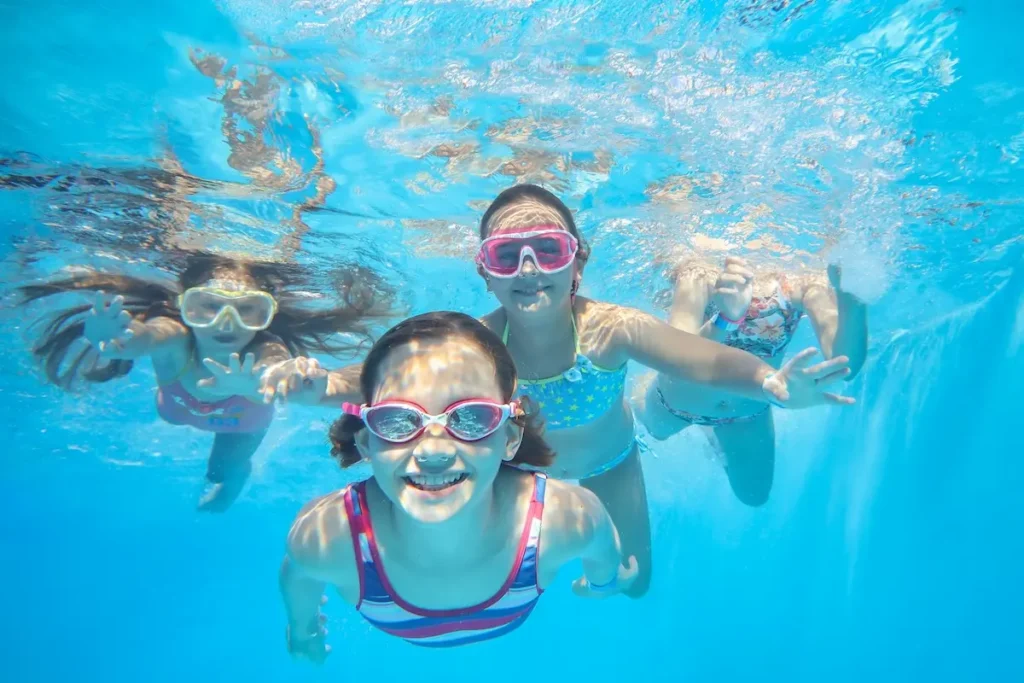 Mehrere Kinder unter Wasser mit Schwimmbrillen